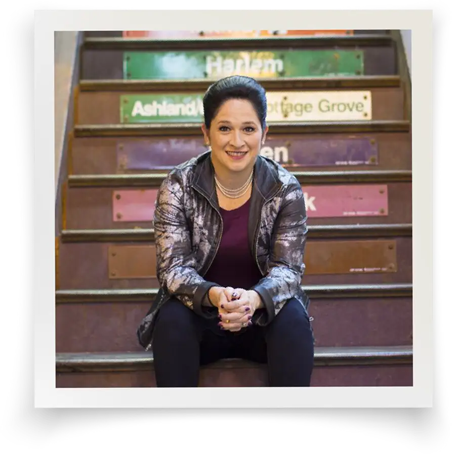 Susana Mendoza sitting on the stairs of a Chicago El platform