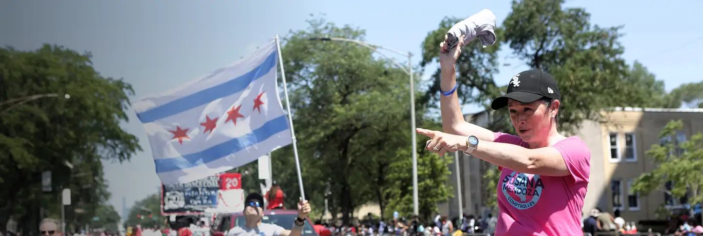 Susana Mendoza throwing a rolled up shirt into a crowd with the Chicago flag in the background